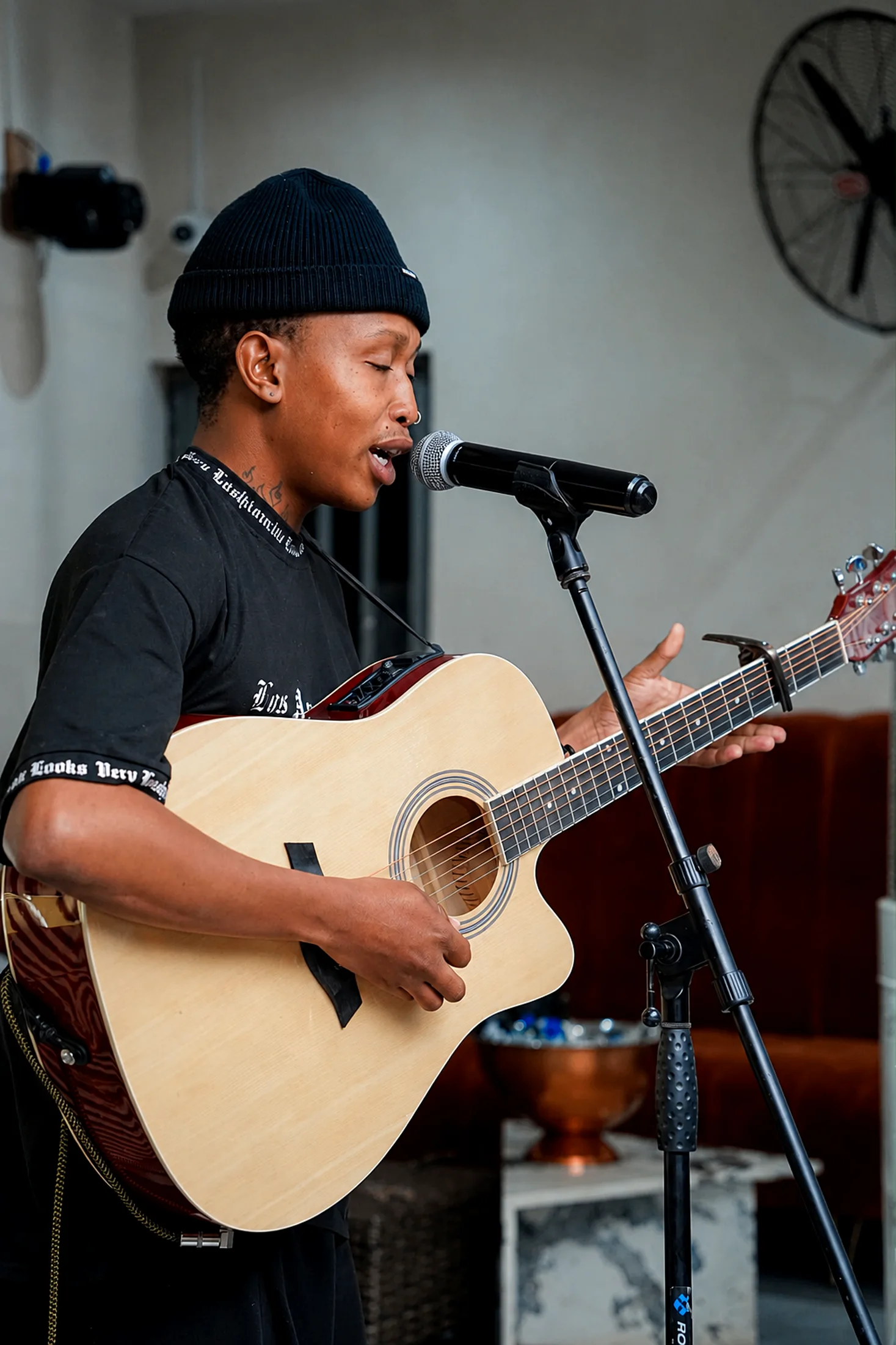 Mahlatse Chokoe performing indoors with acoustic guitar